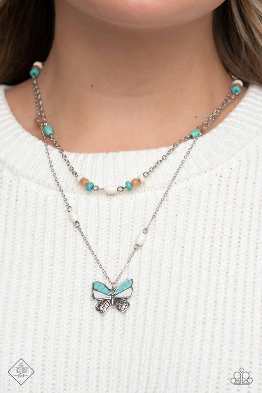 Free-Spirited Flutter - Blue and Silver Butterfly Necklace - Paparazzi Accessories - Oval and round stones in shades of white and turquoise mingle with iced coffee beads, falling down the neckline along two strands of silver chain. An oversized butterfly, with wings of silver filigree and turquoise and white stones, flutters at the bottom of the longest chain in a whimsical finish. Features an adjustable clasp closure. Sold as one individual necklace.