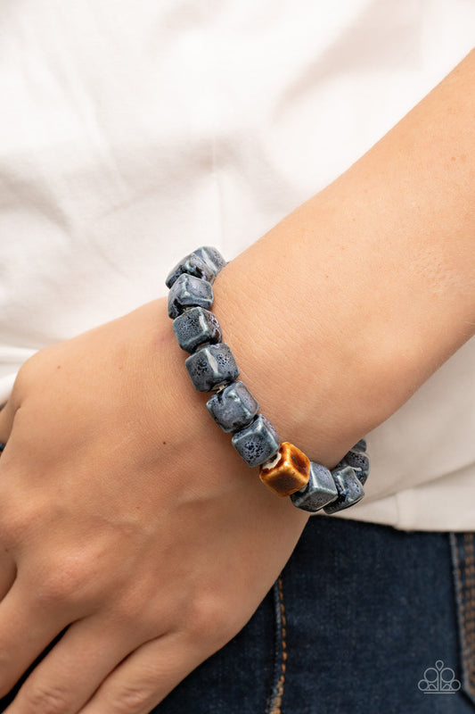 Glaze Craze - Blue and Brown Cube Ceramic Bracelet - Paparazzi Accessories - Featuring distressed blue and brown glazed finishes, a rustic collection of ceramic cube beads are threaded along stretchy bands around the wrist for a colorful flair. Sold as one individual fashion bracelet.