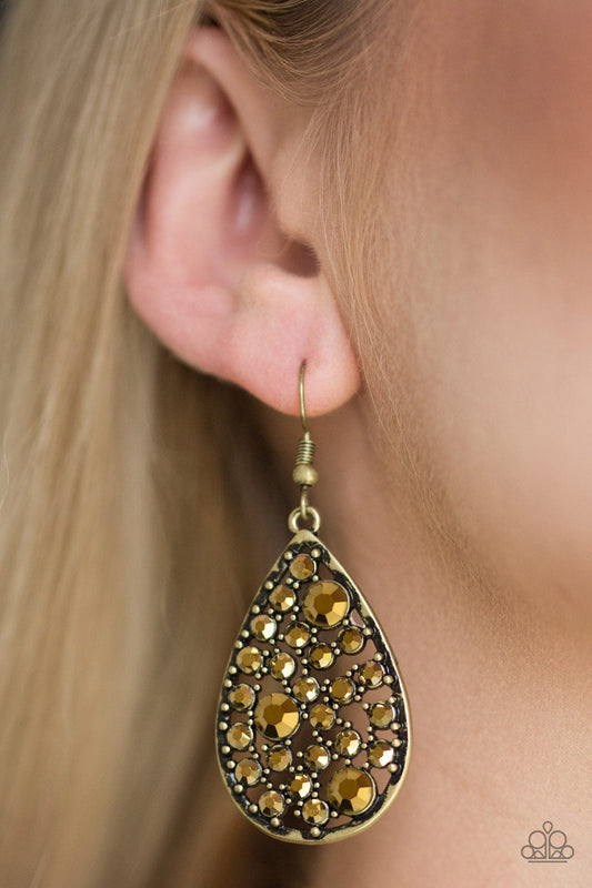 GLOW With The Flow Brass Earrings - Paparazzi Accessories -
Varying in size, glittery aurum rhinestones are sprinkled along a studded brass teardrop for an edgy, yet glamorous look. Earring attaches to a standard fishhook fitting. Sold as one pair of earrings.