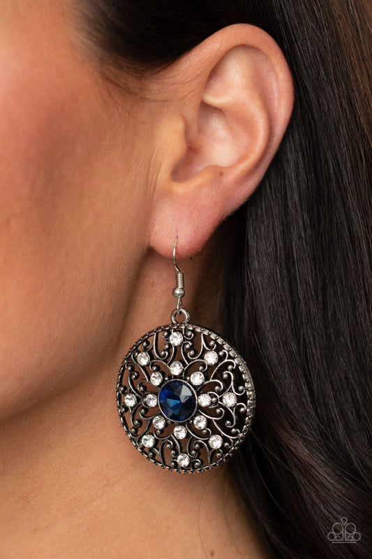 GLOW Your True Colors - Blue and Silver Earrings - Paparazzi Accessories - Dotted in glassy white rhinestones, a backdrop of studded silver vine-like filigree climbs a circular frame. An oversized blue rhinestone embellishes the center for a whimsical finish. Earring attaches to a standard fishhook fitting. Sold as one pair of earrings.