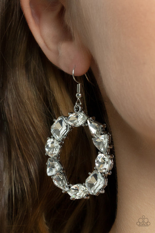 ​GLOWING in Circles - White Sparkle - Silver  Earrings - Paparazzi Accessories - Featuring glistening silver fittings, a regal assortment of round, triangular, teardrop, marquise, and emerald cut white rhinestones delicately coalesce into a jaw-dropping hoop. Earring attaches to a standard fishhook fitting.
Sold as one pair of earrings.
