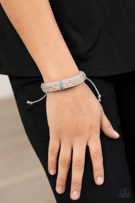Guided Expedition - Lavender Leather Bracelet - Paparazzi Accessories - Glimmering metallic thread is braided with natural twine and laced to the top of a lavender leather band creating a rustic homespun style around the wrist. Features an adjustable sliding knot closure.