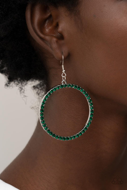 Head-Turning Halo - Glitzy Green and Silver Earrings - Paparazzi Accessories - The front of an oversized silver ring is encrusted in glitzy Leprechaun rhinestones, resulting in a head-turning hoop. Earring attaches to a standard fishhook fitting stylish fashion earrings. 