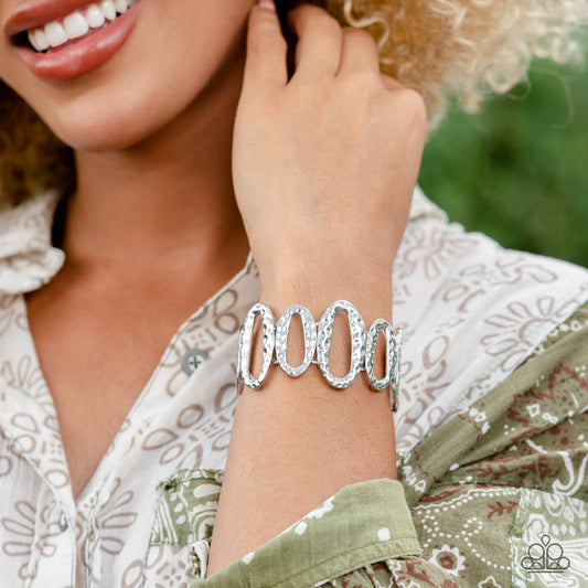 Homestead Heirloom - Silver Bracelet - Paparazzi Accessories - Hammered in a rustic shimmer, an asymmetrical collection of large and medium sized silver oval frames alternates along stretchy bands around the wrist for a handcrafted vibe.