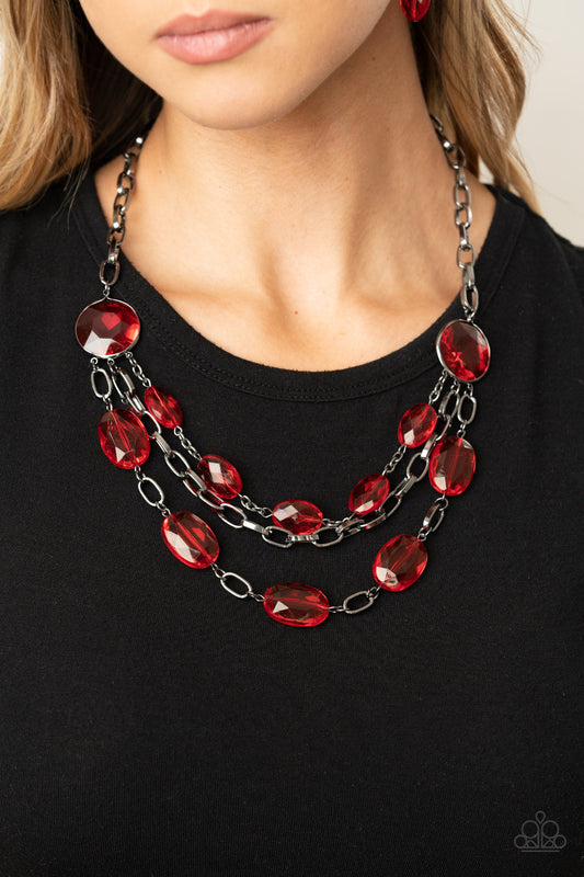 I Need a GLOW-cation - Red and Black Metal Necklace - Paparazzi Accessories - Strung between two matching red gem-like fittings, two glittery rows of red oval gems flank a strand of bold gunmetal chain below the collar for a flawlessly layered look. Features an adjustable clasp closure. 