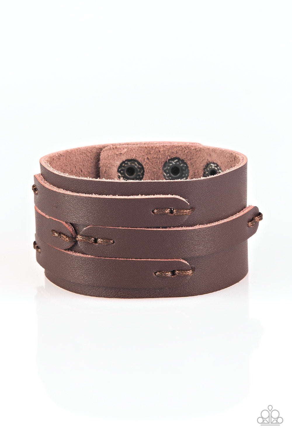 In or OUTLAW - Brown Leather Urban Bracelet - Paparazzi Accessories - Pieces of brown leather are stitched in place across the front of a thick brown leather band for a rugged look. Features an adjustable snap closure. Bejeweled Accessories By Kristie - Trendy fashion jewelry for everyone -