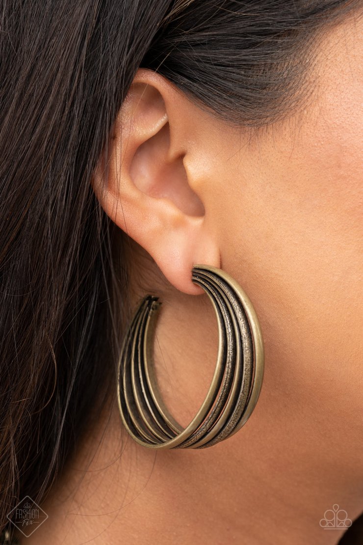 In Sync - Brass Hoop Earrings - Paparazzi Accessories - 
Textured brass rings merge with antiqued matte rings in a curvy ribbon of rustic drama as they wrap around behind the ear. Earring attaches to a standard post fitting. Hoop measures approximately 2" in diameter. Sold as one pair of hoop earrings.
