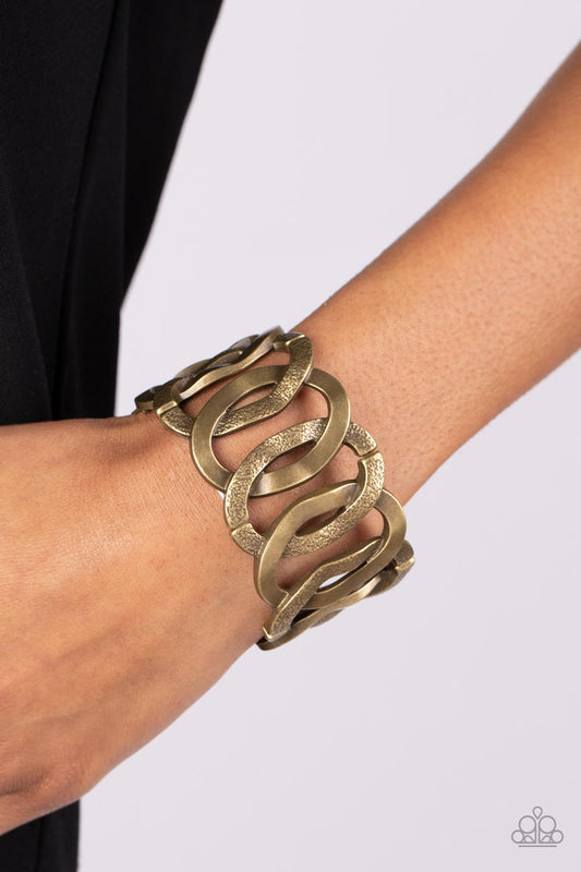 Industrial Indulgence - Brass Stretchy Bracelet - Paparazzi Accessories -  Large brass hoops brushed in gritty texture alternate with smooth brass hoops featuring a high sheen finish. The oversized links overlap as they alternate around the wrist on stretchy bands, culminating in an industrial statement piece. Sold as one individual bracelet.