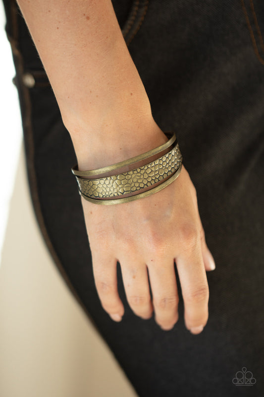 Jungle Jingle - Brass Cuff Fashion Bracelet - Paparazzi Accessories - Embossed in metallic crocodile-like print, an antiqued brass cuff attaches to the center of an airy brass cuff for a wildly stacked look. Sold as one individual bracelet.