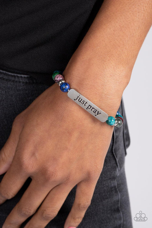 Just Pray - Multi Color Bracelet - Paparazzi Accessories - Smooth, multicolored speckled stones are stretched across the wrist on an elastic stretchy band, with accents of silver beads sprinkled in. Meeting in the center of the stony display, a curved rectangular bar is stamped with the phrase just pray" for an inspiring finish.