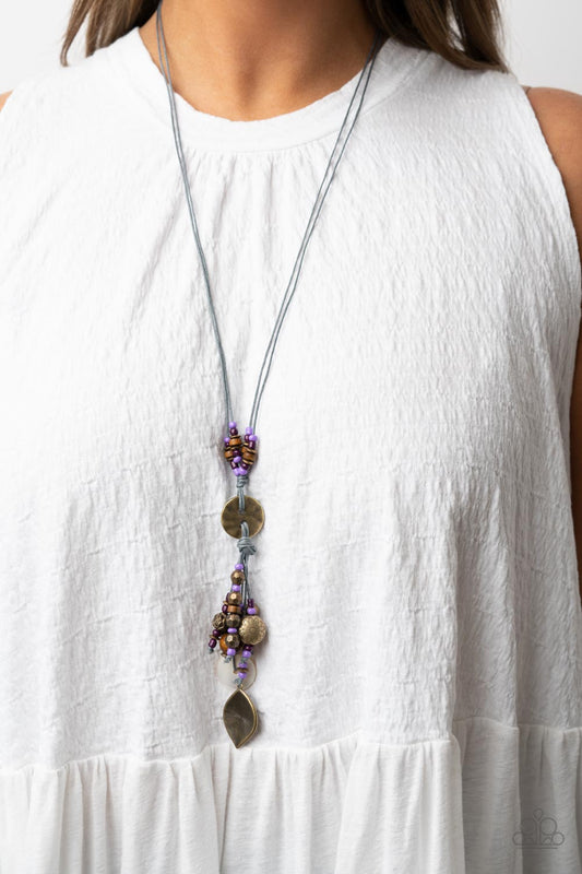 Knotted Keepsake - Purple Seed Bead - Brass Necklace - Paparazzi Accessories - An earthy assortment of purple and plum seed beads, rustic brass discs, and wooden accents glide along lengthy strands of gray cording that knot around a hammered brass disc. Tassels of matching beads, a white shell-like accent, floral silver bead, and brass leaf charm dance from the bottom, adding playful movement to the free-spirited display. Features an adjustable clasp closure. Sold as one individual necklace.