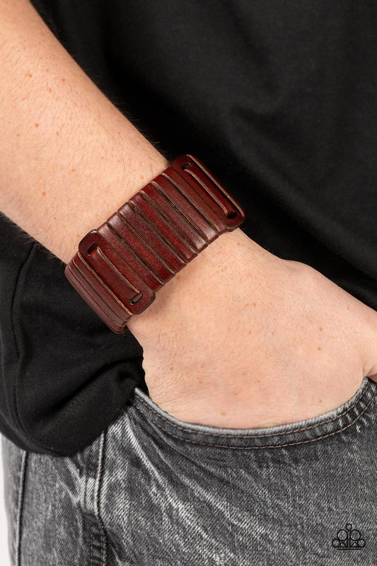 Leather Lumberyard - Brown Urban Bracelet - Paparazzi Accessories - A brown leather lace is wrapped around and through a thick brown leather band, resulting in a rugged centerpiece around the wrist. Features an adjustable snap closure.
