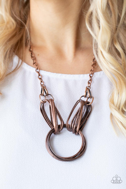 Lip Sync Links - Copper Necklace - Paparazzi Accessories - Layers of oblong copper links attach to a collection of oversized antiqued copper rings creating a dramatic centerpiece. Attached to a copper chain, the rustic links create an unconventionally edgy statement below the collar.