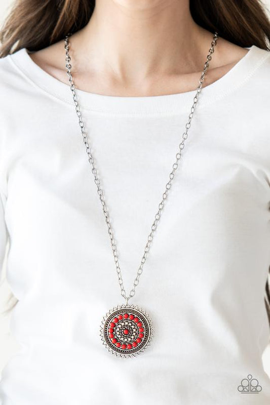 Lost SOL - Red and Silver Necklace - Paparazzi Accessories - Radiating with shimmery sunburst details, a red beaded silver pendant swings from the bottom of a lengthened silver chain for a tribal inspired style necklace.