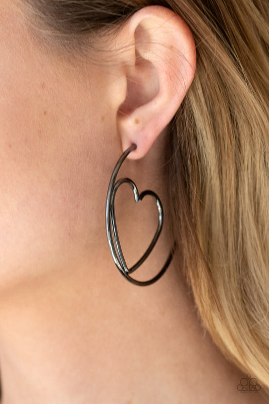 Love At First BRIGHT - Black - Gunmetal Hoop Earrings - Paparazzi Accessories - Glistening gunmetal wire delicately bends into an airy heart frame inside a classic gunmetal hoop, creating a flirtatious display. Earring attaches to a standard post fitting. Hoop measures approximately 2" in diameter. 