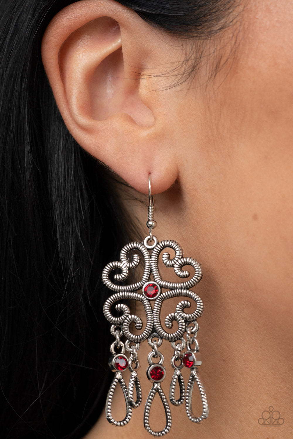 Majestic Makeover - Red and Silver Earrings - Paparazzi Jewelry - Bejeweled Accessories By Kristie - Etched in linear texture, four whimsical hearts coalesce into an airy frame. A dainty red rhinestone dots the center while a flirty fringe of teardrop frames adorned with fiery red rhinestones sways below for an eye-catching finish. Earring attaches to a standard fishhook fitting.