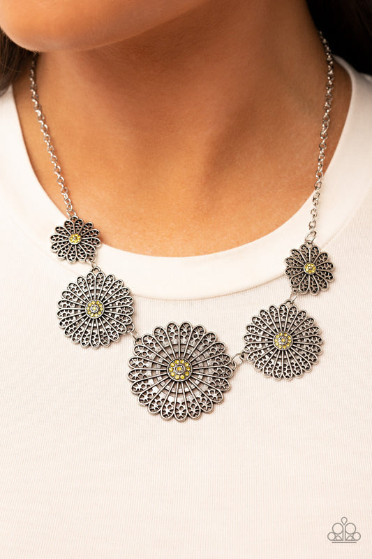 Marigold Meadows - Yellow and Silver Floral Necklace - Paparazzi Accessories - Infused with a whimsical mandala-like motif, tactile silver petals bloom from yellow rhinestone dotted centers below the collar. The mismatched silver flowers gradually increase in size, exaggerating the eye-catching details. Features an adjustable clasp closure.