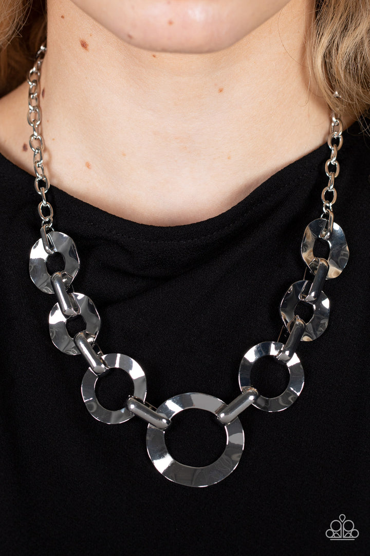 Mechanical Masterpiece - Silver Necklace - Paparazzi Jewelry - Bejeweled Accessories By Kristie - Featuring hammered surfaces, crinkled silver rings gradually increase in size as they alternate with bold silver fittings below the collar for an intense industrial fashion. Features an adjustable clasp closure. Sold as one individual necklace.