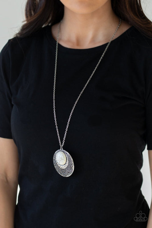 Medallion Meadow - White Crackle Stone and Silver Necklace - Paparazzi Accessories -  Refreshing white stone is pressed into a hammered silver medallion radiating with floral details swings from a long silver chain for a bold tribal stylish necklace.