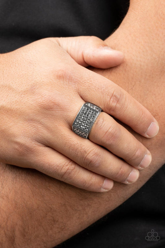 Metro Merger - Silver Ring - Paparazzi Accessories - The front of a rectangular silver frame is encrusted in sections of hematite rhinestones, resulting in a smoldering centerpiece atop the finger. Features a stretchy band for a flexible fit. Sold as one individual ring.