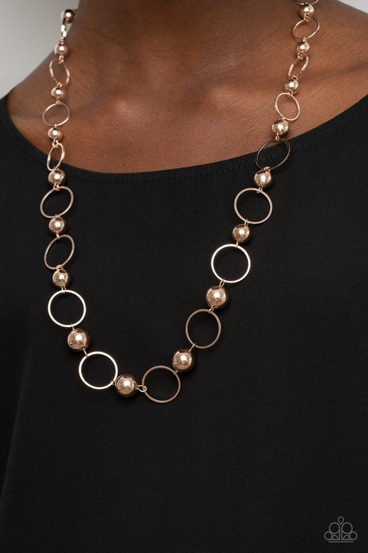 Metro Milestone - Gold Necklace - Paparazzi Accessories - Gradually increasing in size, a glistening collection of rose gold beads and rose gold hoops alternate across the chest for a classic metallic fashion. Features an adjustable clasp closure. Sold as one individual necklace.