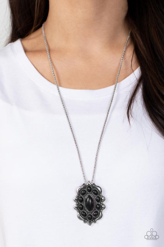Mojave Medallion - Black Stone - Silver Necklace - Paparazzi Accessories - Earthy black oval stones embellish the front of a decoratively scalloped silver frame, creating a whimsical floral pendant at the bottom of an extended silver popcorn chain.