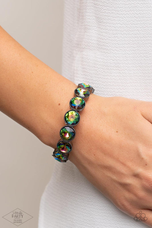 Number One Knockout - Multi Oil Spill Rhinestone Bracelet - Paparazzi Accessories - Oil spill gems are pressed into sleek gunmetal frames. The glittery frames are threaded along stretchy bands, creating a glamorous look around the wrist.