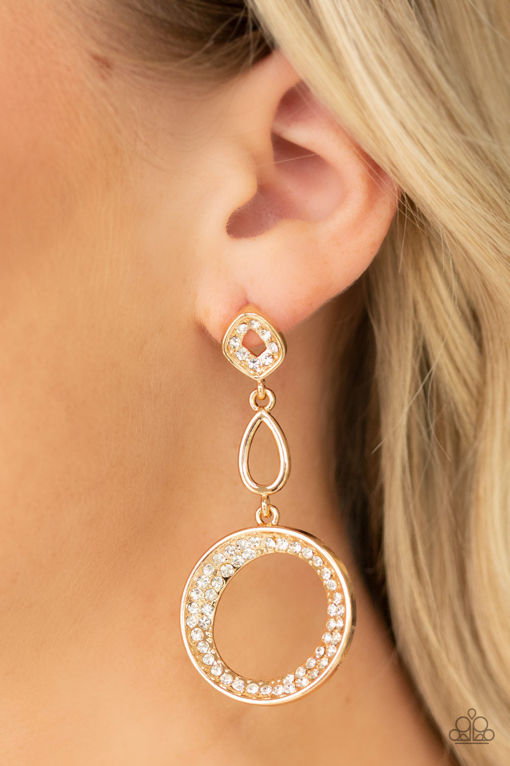 On The Glamour Scene - Gold Post Earrings - Paparazzi Accessories - Rows of glassy white rhinestones, mismatched beveled gold frames link with a golden teardrop as they trickle from the ear, coalescing into a glamorous lure. Earring attaches to a standard post fitting.