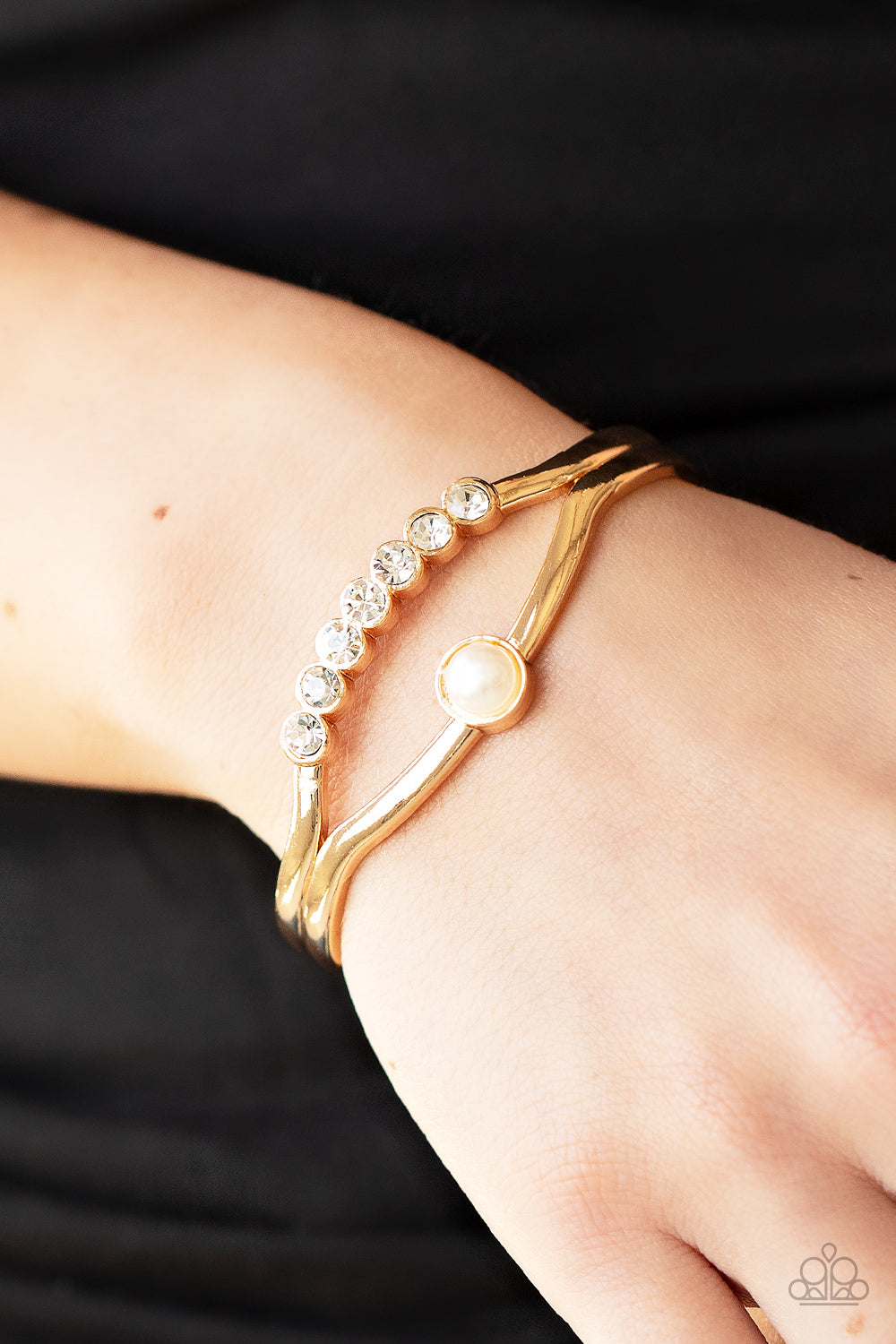 Palace Prize - Gold Pearl Bracelet - Paparazzi Accessories - A row of glassy white rhinestones and a solitaire white pearl adorn the layered center of a classic gold cuff, creating a timeless piece around the wrist. Sold as one individual bracelet.