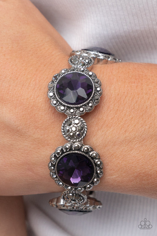 Palace Property - Purple and Silver Bracelet - Paparazzi Accessories - An oversized purple rhinestone adorns the center of a hematite rhinestone petaled floral frame. Infused with hematite dotted silver accents, the glitzy floral frames sparkle along stretchy bands around the wrist for a glamorous finish. Sold as one individual bracelet.