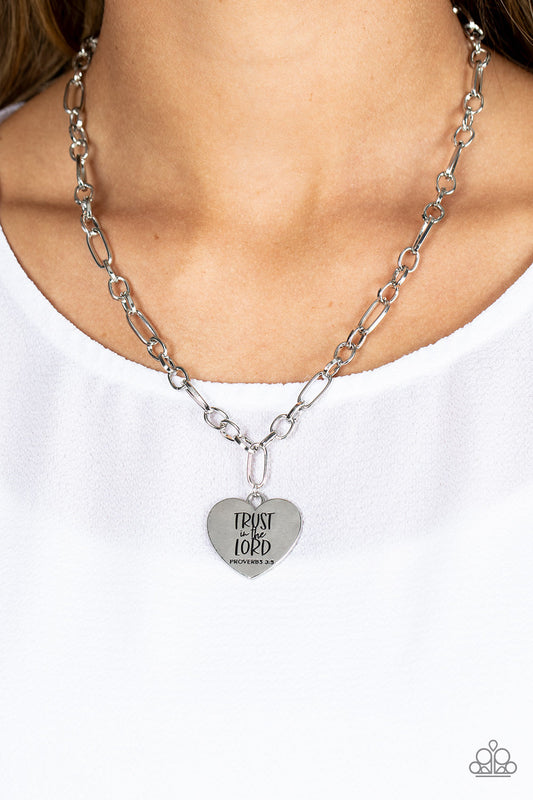 Perennial Proverbs - Silver Heart Necklace - Paparazzi Accessories - Dangling from a silver figaro chain, a charming heart pendant swings. Stamped upon the shiny surface, the phrase "Trust in the Lord" with the bible reference listed below it "Proverbs 3:5" are listed in different fonts for an optimistic and hopeful finish. Features an adjustable clasp closure. Sold as one individual necklace.