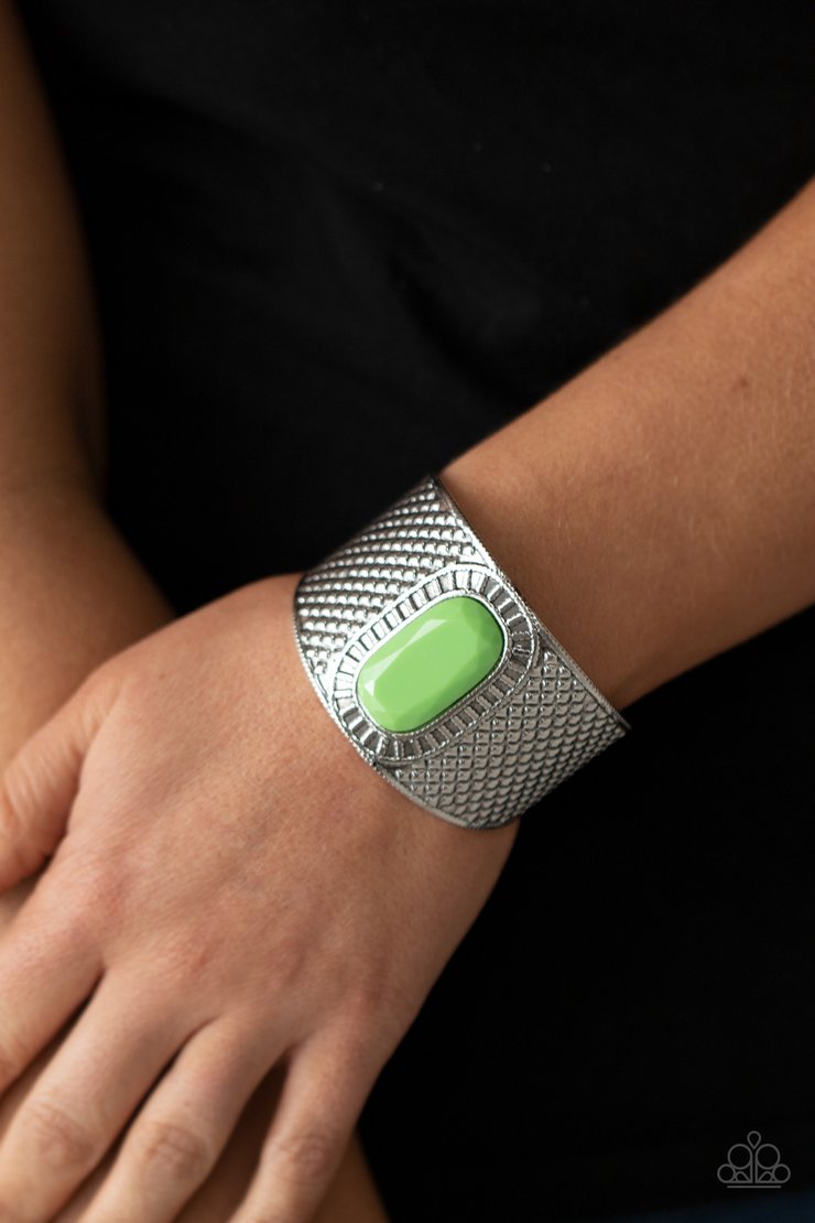 Poshly Pharaoh - Green and Silver Cuff Bracelet - Paparazzi Accessories - An oversized faceted green bead is pressed into the center of a thick silver cuff embossed in diamond-like textures, creating a bold tribal inspired centerpiece around the wrist. Sold as one individual bracelet.