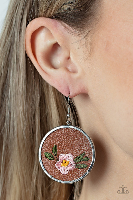 Prairie Patchwork - Pink Flower Earrings - Paparazzi Accessories - A leafy Gossamer Pink flower is embroidered along the bottom of a piece of leather that is encased in a sleek silver frame, blooming into a homespun fashion. Earring attaches to a standard fishhook fitting. Sold as one pair of earrings.