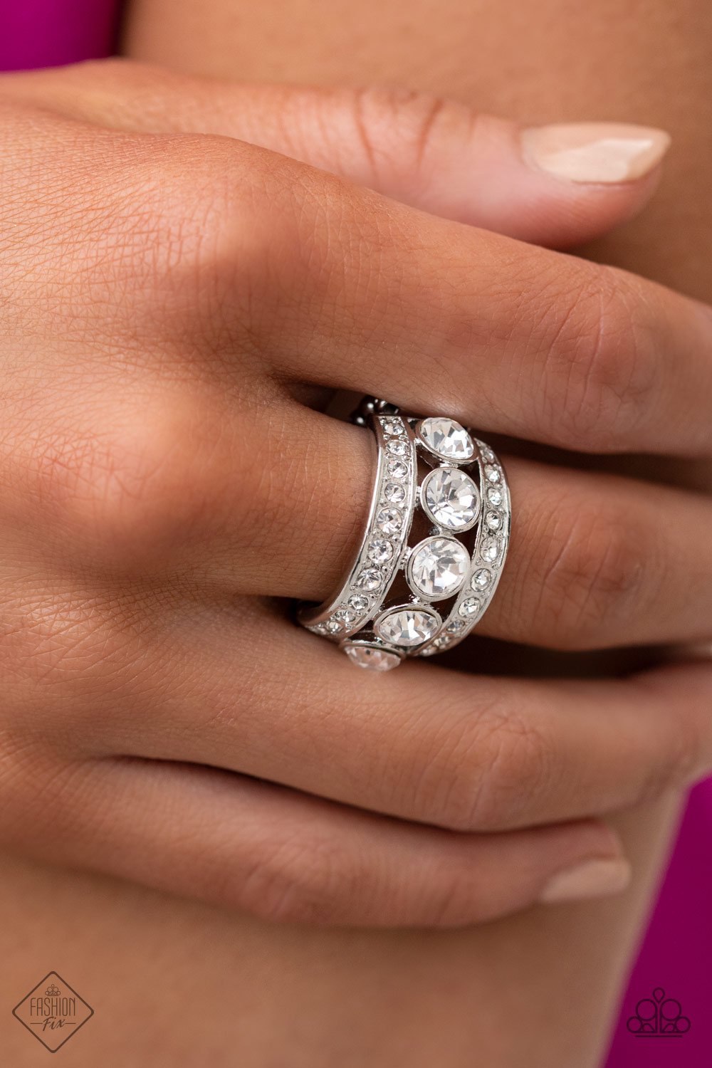 Princess Pedigree White and Silver Ring - Paparazzi Accessories - A row of oversized white rhinestones is flanked by two silver bands encrusted in even more glassy white rhinestones, creating a brilliantly blinding display across the finger. Features a stretchy band for an adjustable flexible fit.