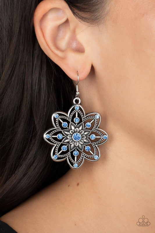 Prismatic Perennial - Blue and Silver Earrings - Paparazzi Accessories - Dotted in Glacier Lake rhinestones, rows of smooth and studded silver petals bloom from a Glacier Lake rhinestone center for a whimsical floral fashion.