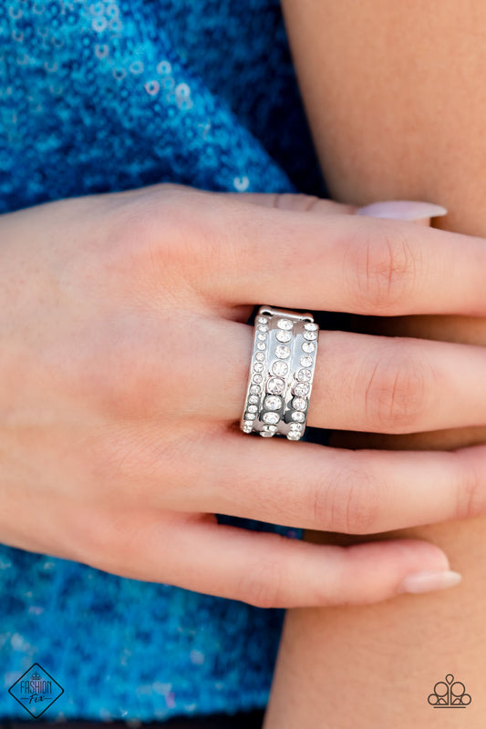 Privileged Poise - White and Silver Fashion Ring - Paparazzi Accessories - A thick band of high-sheen silver is topped with three rows of glittery white rhinestones, creating the illusion of three separate bands. The rhinestones gradually decrease in size from the centermost band, adding depth and dimension to the poised centerpiece. Features a stretchy band for a flexible fit. Sold as one individual ring.