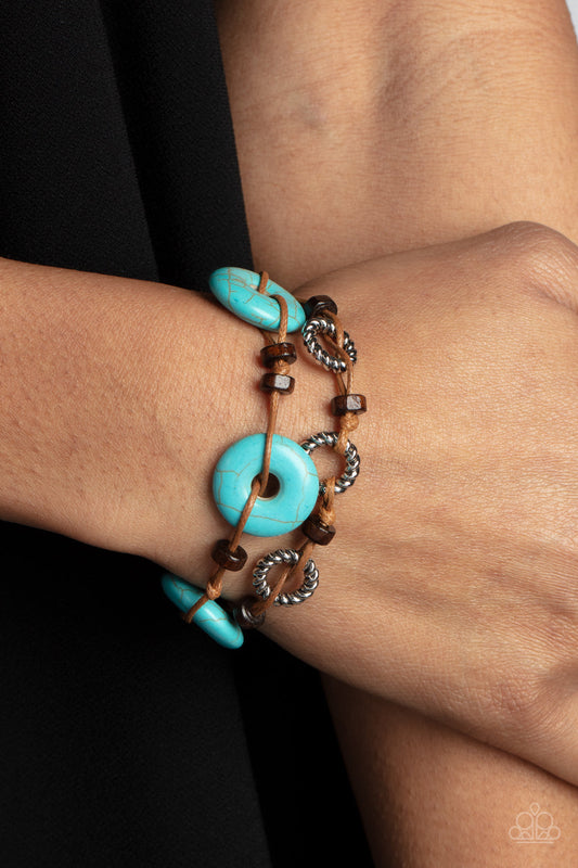 Quarry Quandary - Blue Turquoise Wood Bracelet - Paparazzi Accessories - An earthy assortment of wooden beads, textured silver rings, and turquoise stone discs are knotted in place along two brown suede cords, for adventurous layers around the wrist.