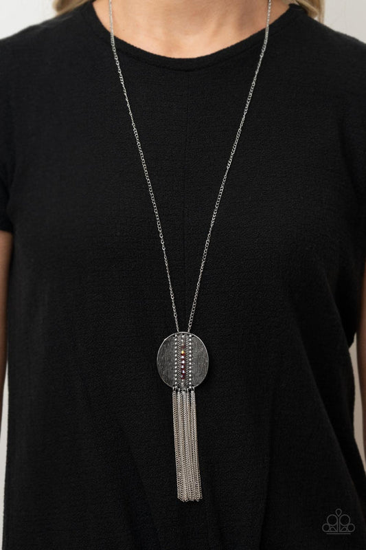 Radical Refinery - Red and Silver Necklace - Paparazzi Accessories - An oversized concave silver disc, ribbed with linear texture, creates a dramatic backdrop for a vertical row of faceted red beads. A flirty tassel of delicate silver chains sways from the bottom of the pendant for a sassy finish at the bottom of a lengthened silver chain. Features an adjustable clasp closure. Sold as one individual necklace.