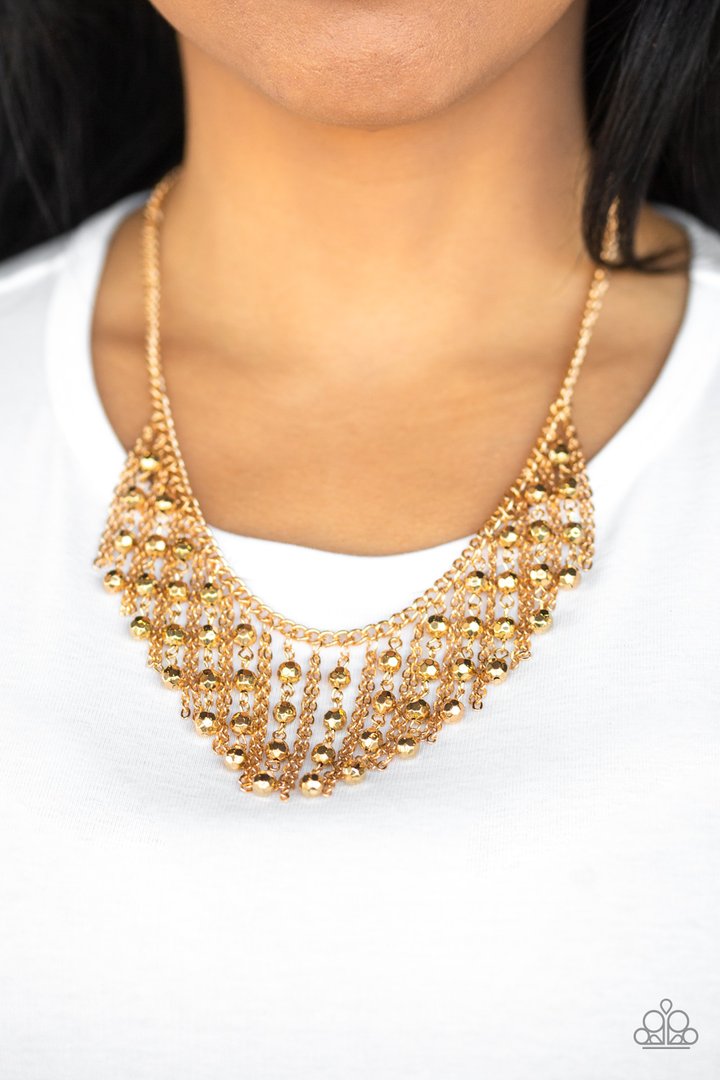 Rebel Remix - Gold Fashion Necklace - Paparazzi Accessories - Stands of faceted gold beads and glistening gold chains stream from a matching gold chain, creating an edgy fringe below the collar. Features an adjustable clasp closure necklace. 