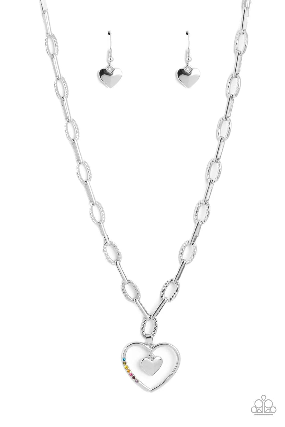 Refulgent Heart - Multi Color and Silver Necklace - Paparazzi Accessories - Textured ovals and elongated silver links lead the eye down to an oversized, airy, silver heart frame. Encrusted along one of the curves of the silver heart, dainty rhinestones glimmer for a subtle pop of color. Dangling inside the oversized heart frame, a silver heart pendant swings for a romantic finish.