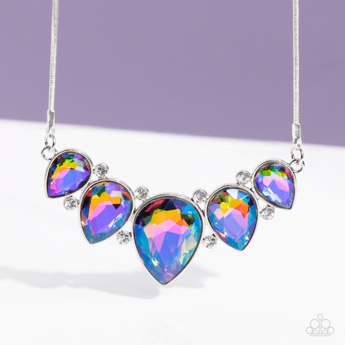 Regally Refined - Multi Color Teardrop Necklace - Paparazzi Accessories - Featuring a stellar UV shimmer, dramatic teardrop gems, gliding from a sleek, silver snake chain, are pressed into high-sheen silver casings, creating a colorful fringe below the collar. Linking each teardrop together, dainty white rhinestones border the tops and bottoms of each shape, creating additional eye-catching dazzle.