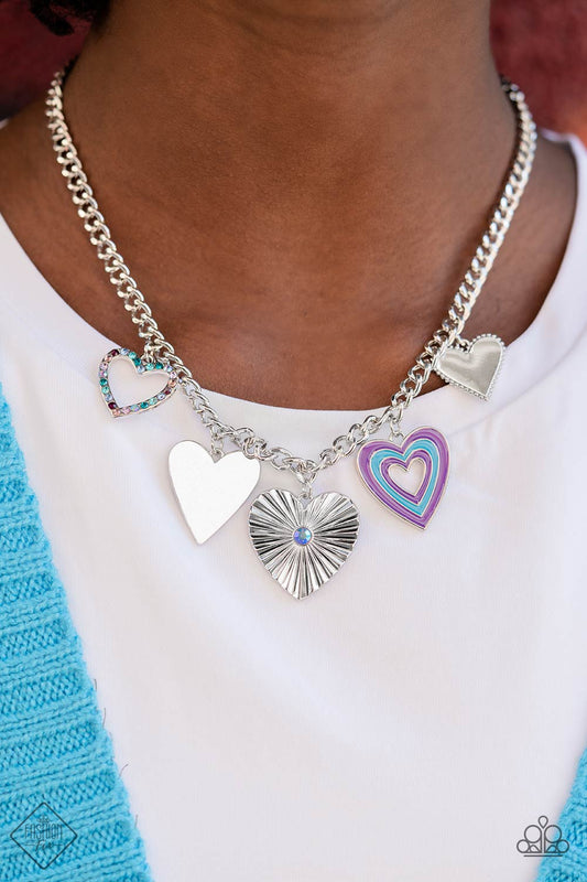Retro Rhapsody - Blue Purple and Silver Heart Necklace - Paparazzi Accessories - A collection of whimsical heart charms, each with its own unique features, gathers along a flat, silver curb chain. The whimsical charms and intricate details coalesce to create a youthful and vibrant design.