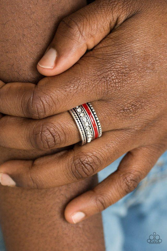 Rich Rogue - Red and Silver Ring - Paparazzi Accessories - A shiny red strip of color runs along the bottom of a row of glassy white rhinestones. Infused with silver textures, the mismatched details coalesce into one thick band across the finger. Features a stretchy band for a flexible fit. Sold as one individual ring.