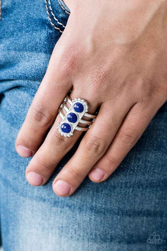Rio Trio - Blue and Silver Ring - Paparazzi Accessories - Infused with glassy blue beads, a studded silver frame is pressed into the center of a layered silver band for a seasonal look. Features a stretchy band for a flexible fit. Sold as one individual ring.