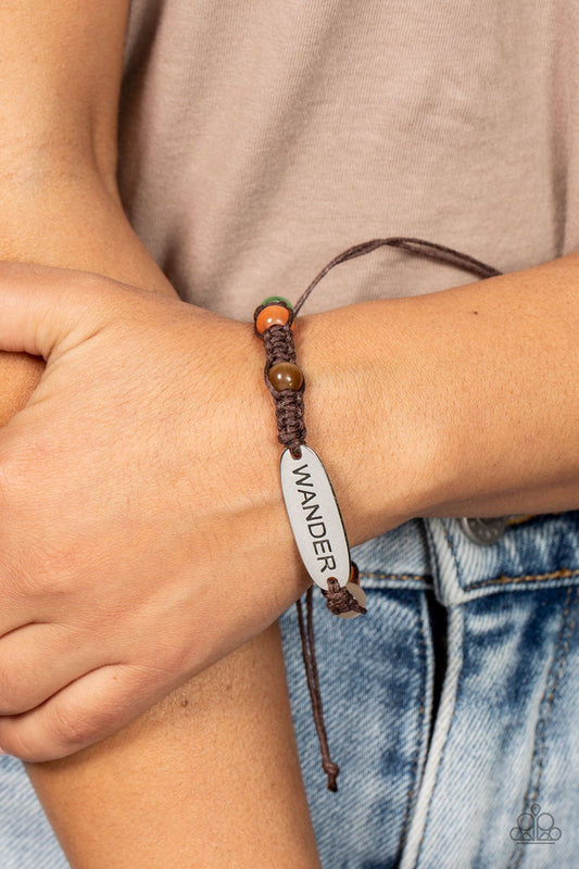 Roaming For Days - Multi Bracelet - Paparazzi Accessories - Glassy multicolored cat's eye stone beads are knotted in place along a strand of braided brown cording that attaches to a silver centerpiece stamped in the word, "Wander," for a free-spirited fashion. Features an adjustable sliding knot closure.