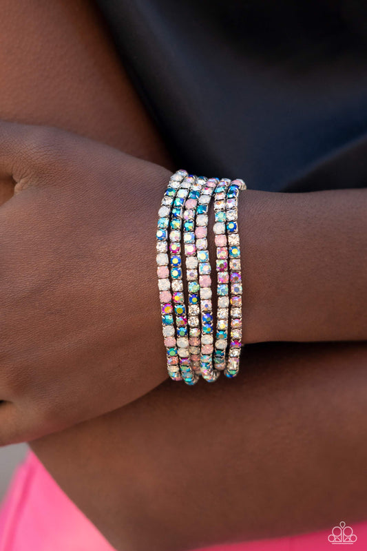 Rock Candy Rage - Multi Color Bracelet - Paparazzi Accessories - Embellished in rhinestone studs, six bracelets threaded along elastic stretchy bands stack across the wrist. Opalescent white, clear, and shades of iridescent in fuchsia, baby pink, and blues create a dramatic collision of color and shimmer. Due to its prismatic palette, color may vary. Sold as set of six bracelets.