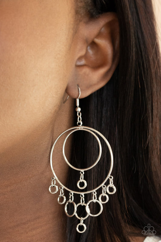 Roundabout Radiance - Silver Fringe Earrings - Paparazzi Accessories - A dainty collection of silver rings swing from the bottom of interconnected silver hoops, creating a dizzying fringe. Earring attaches to a standard fishhook fitting.