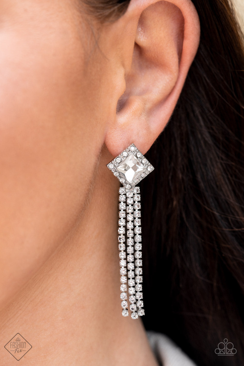Seasonal Sparkle - White Rhinestone - Silver Earrings - Paparazzi Accessories - A brilliant, square-cut white rhinestone is bordered by tiny sparkling accents and tilted on a point, creating a dramatic anchoring point from which streams of glittery, square-cut rhinestones cascade from the ear in a glitzy finish. Earring attaches to a standard post fitting. Sold as one pair of post earrings.