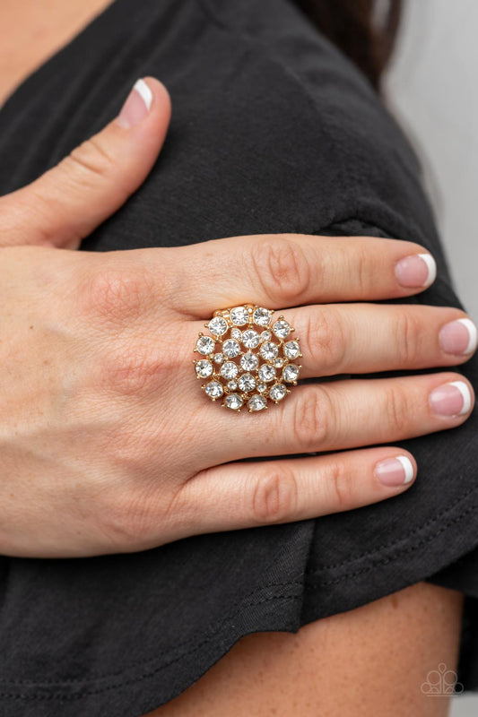 SELFIE-Confidence Gold Ring - Paparazzi Accessories - Featuring pronged gold fittings, an explosion of glassy white rhinestones sparkles atop the finger for a statement-making fashion. Features a stretchy band for a flexible fit.