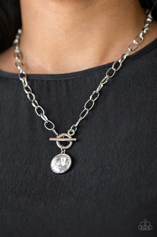 She Sparkles On - White and Silver Necklace - Paparazzi Accessories - A dramatic gem white swings from the bottom of a shiny silver chain, creating a blinding pendant below the collar. Features a toggle closure. Sold as one individual necklace.